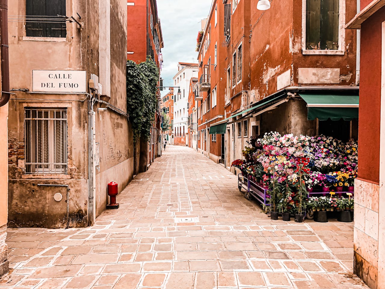 Picturesque street with vibrant flowers and old buildings in a historic town.