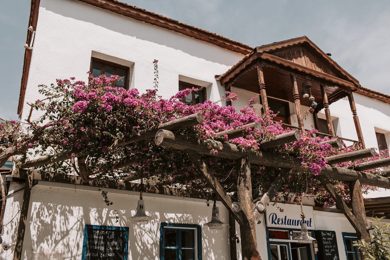 Traditional restaurant facade adorned with blooming bougainvillea in Antalya, Turkey.